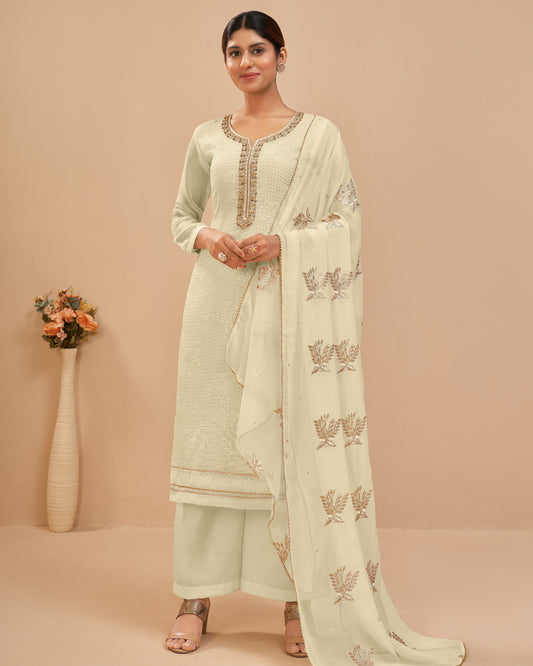 Woman wearing a light green traditional outfit with a matching dupatta on a beige background