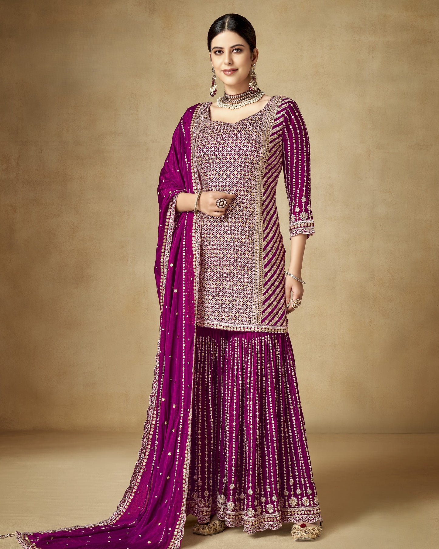 Woman wearing a traditional outfit with a purple and pink color scheme on a beige background