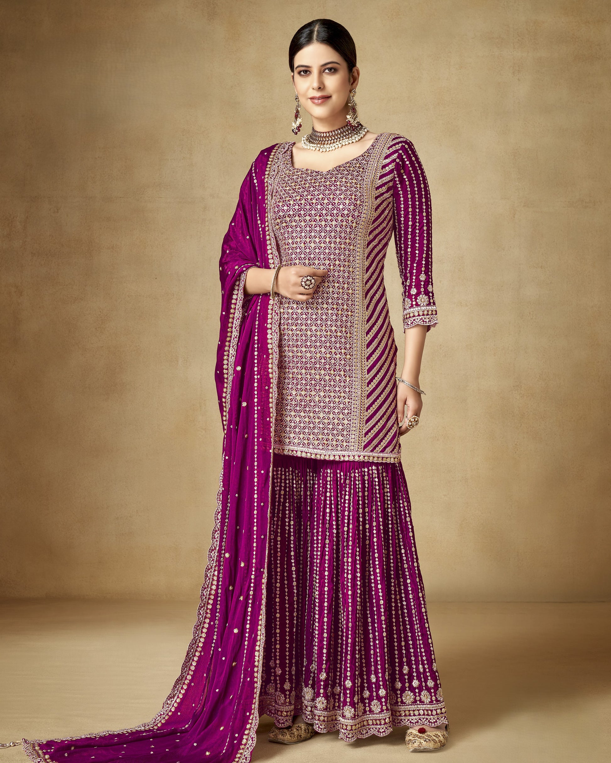 Woman wearing a traditional outfit with a purple and pink color scheme on a beige background