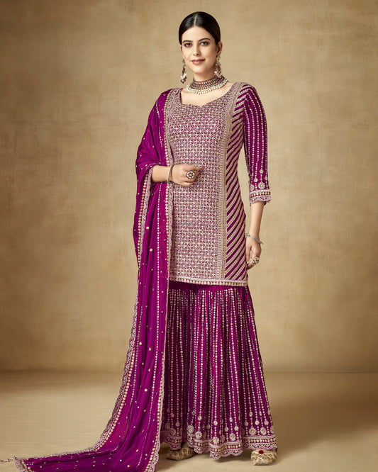 Woman wearing a traditional outfit with a purple and pink color scheme on a beige background