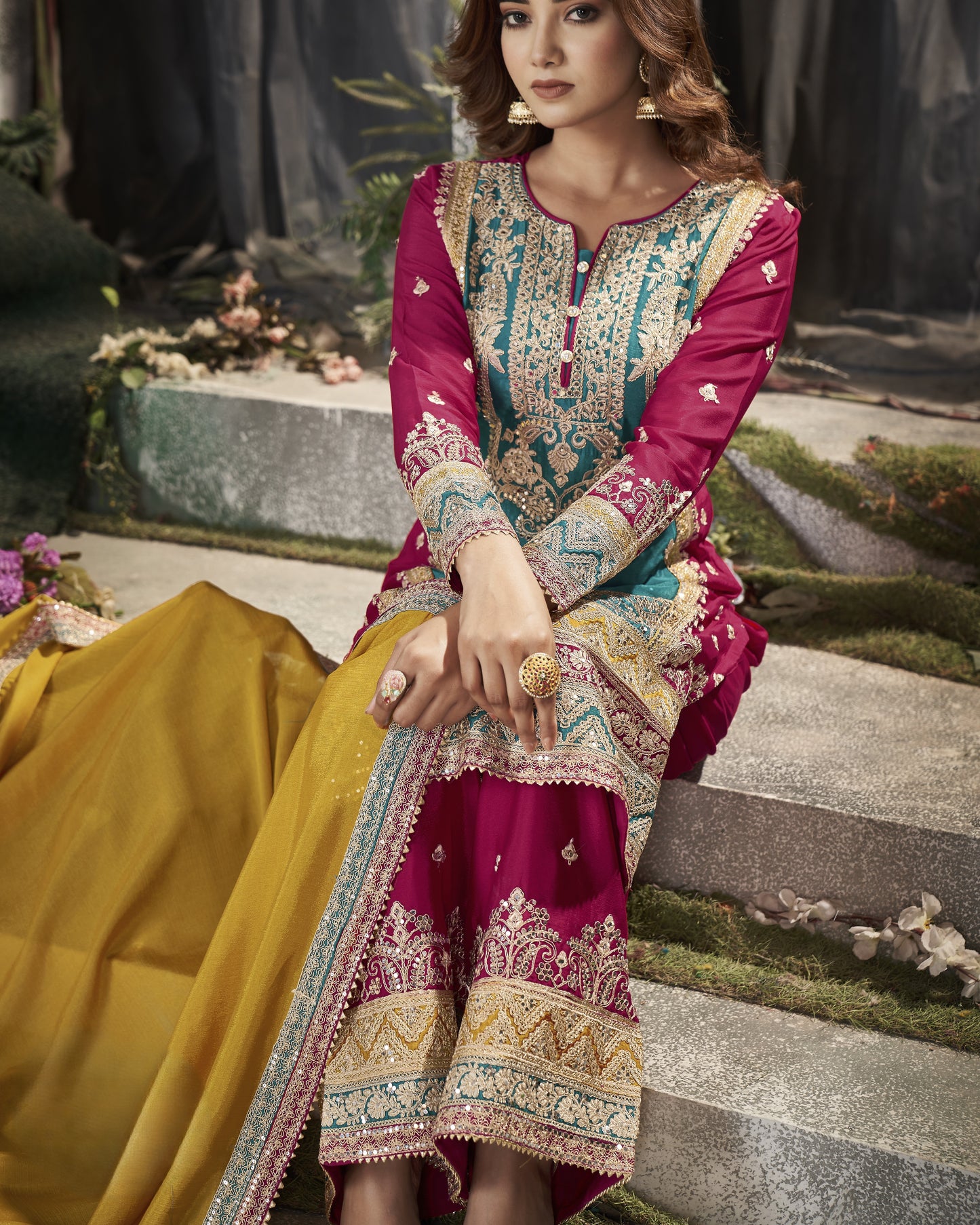 Woman in a traditional embroidered dress sitting outdoors.