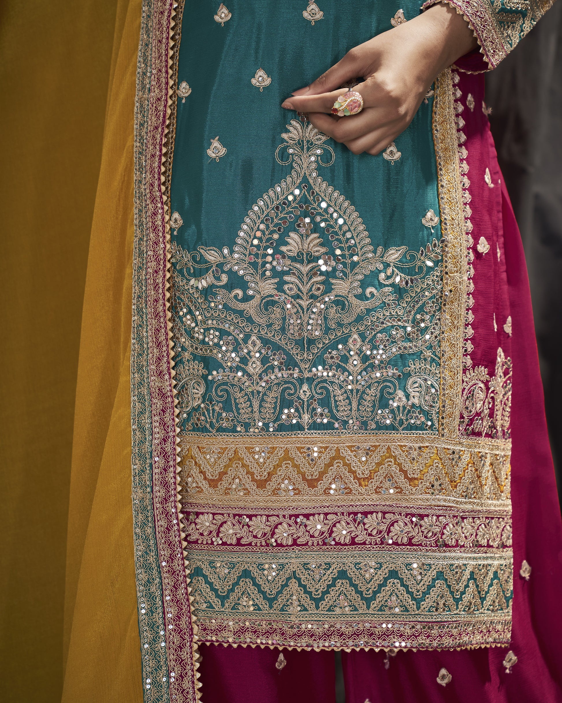 Close-up of a person wearing a traditional embroidered outfit with intricate patterns.