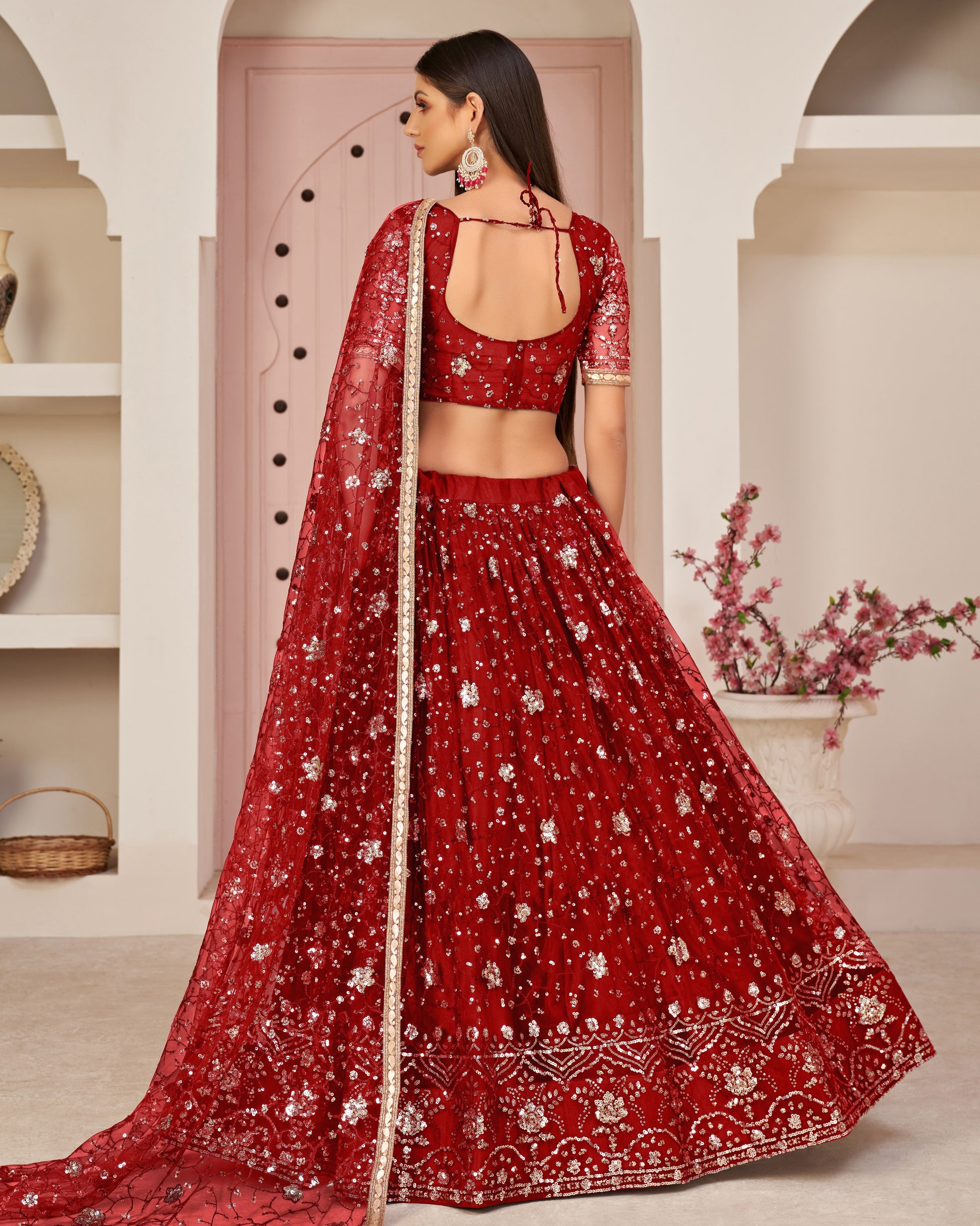 Red embroidered traditional outfit with a matching dupatta against a neutral background