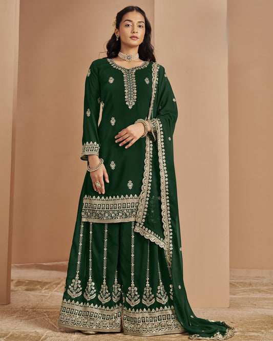 Woman wearing a green embroidered traditional outfit against a beige background
