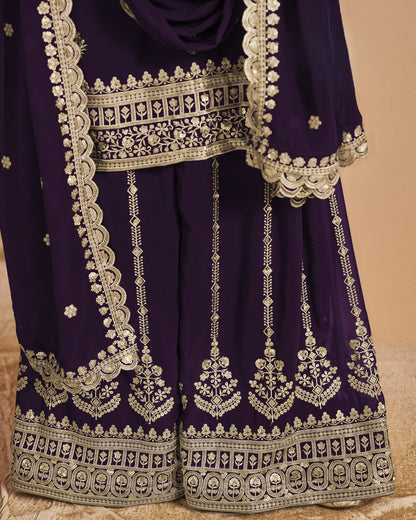 Purple traditional outfit with intricate white embroidery on a beige background