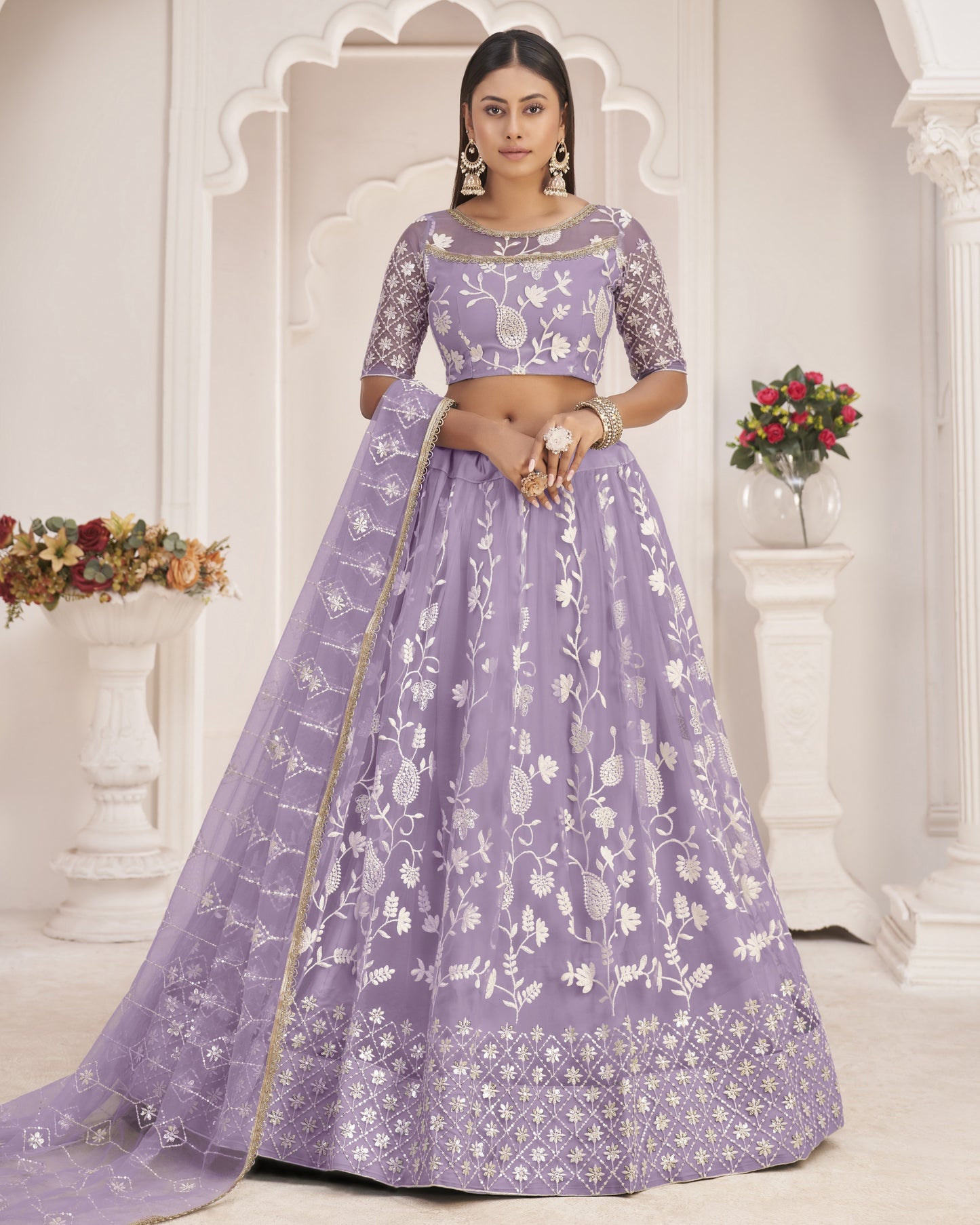 Woman wearing a purple floral lehenga in an elegant indoor setting