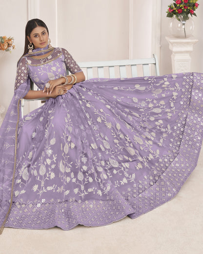 Woman wearing a purple saree with white floral patterns in a well-lit room.