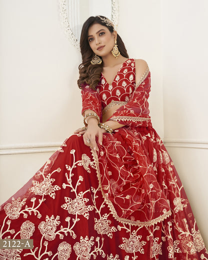 Woman wearing a red embroidered traditional outfit with gold jewelry against a white background