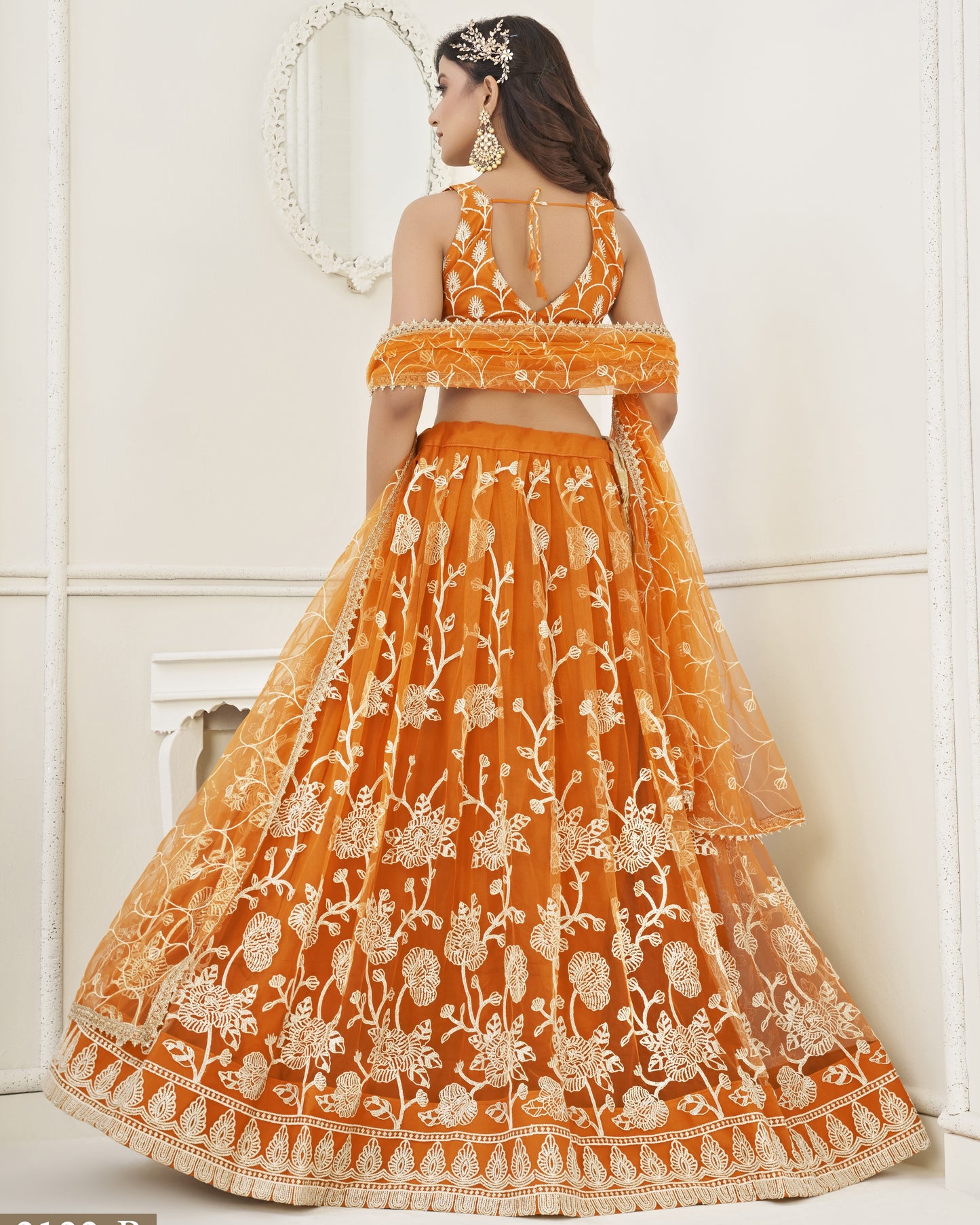 Orange embroidered lehenga with white floral patterns on a white background