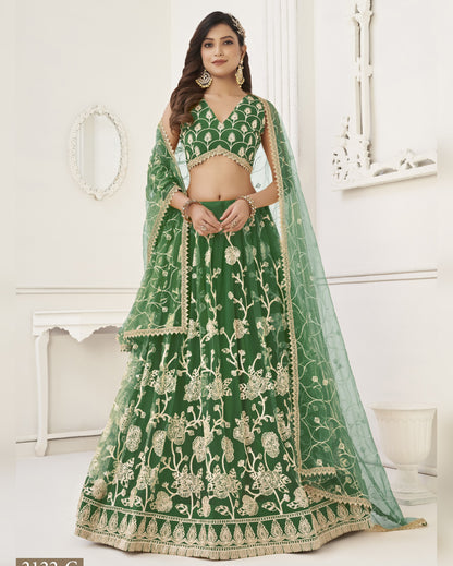 Woman wearing a green embroidered lehenga with a white background