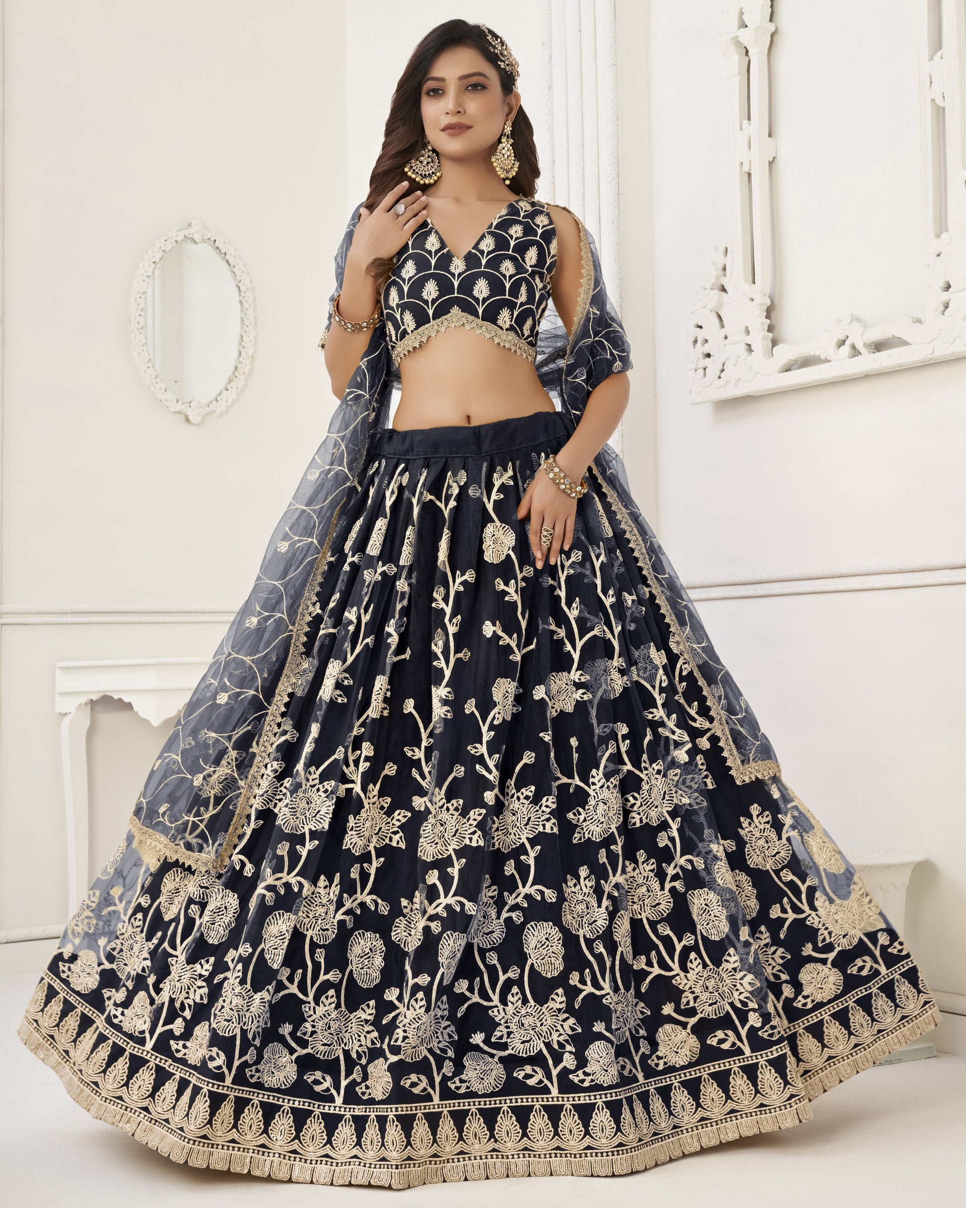 Navy blue embroidered lehenga with gold details on a white background