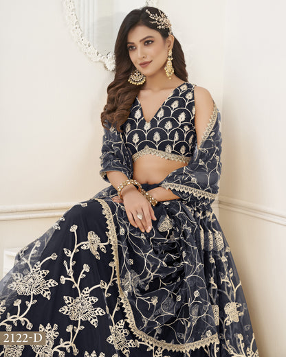 Woman wearing a navy blue embroidered traditional outfit with gold details against a white background