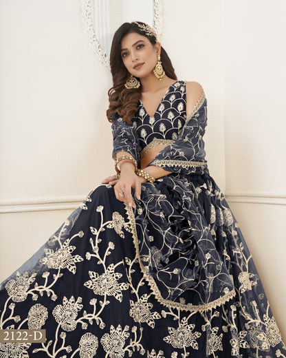 Woman wearing a navy blue embroidered traditional outfit with gold details against a white background