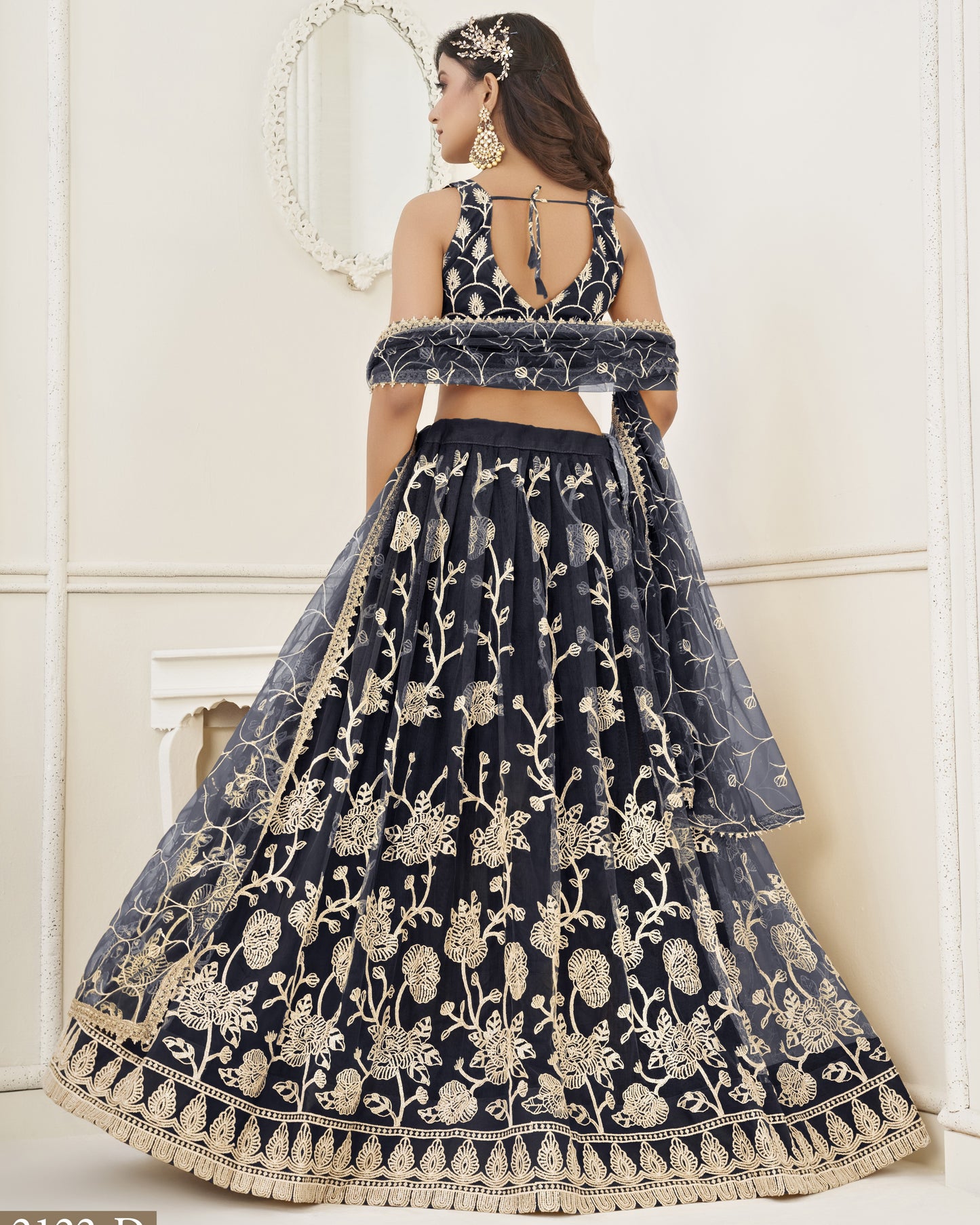 Navy blue embroidered lehenga with gold details on a white background
