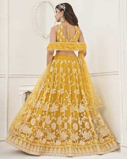 Woman wearing a yellow embroidered lehenga with a white background