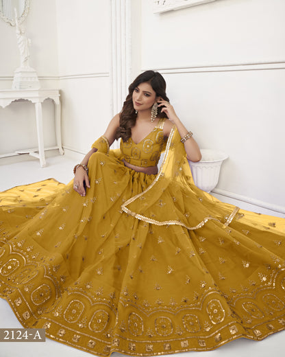 Woman in a yellow embroidered traditional outfit sitting on a white couch.