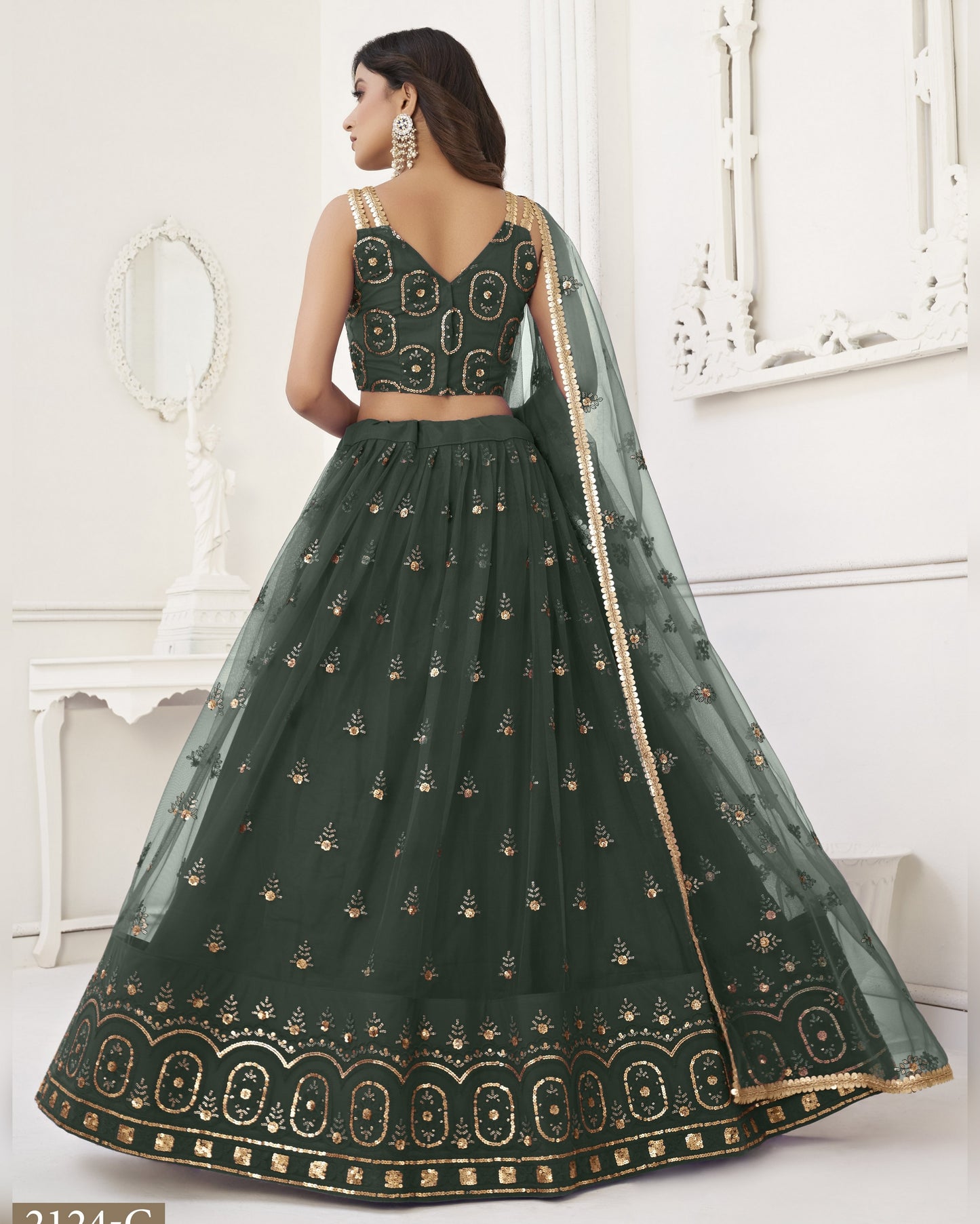 Green embroidered lehenga with gold details on a white background