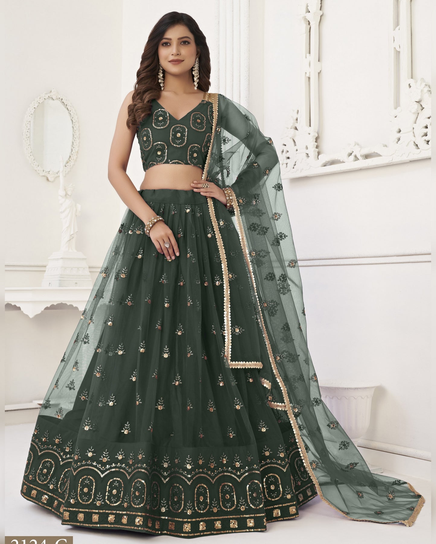 Green embroidered lehenga with matching blouse and dupatta on a white background