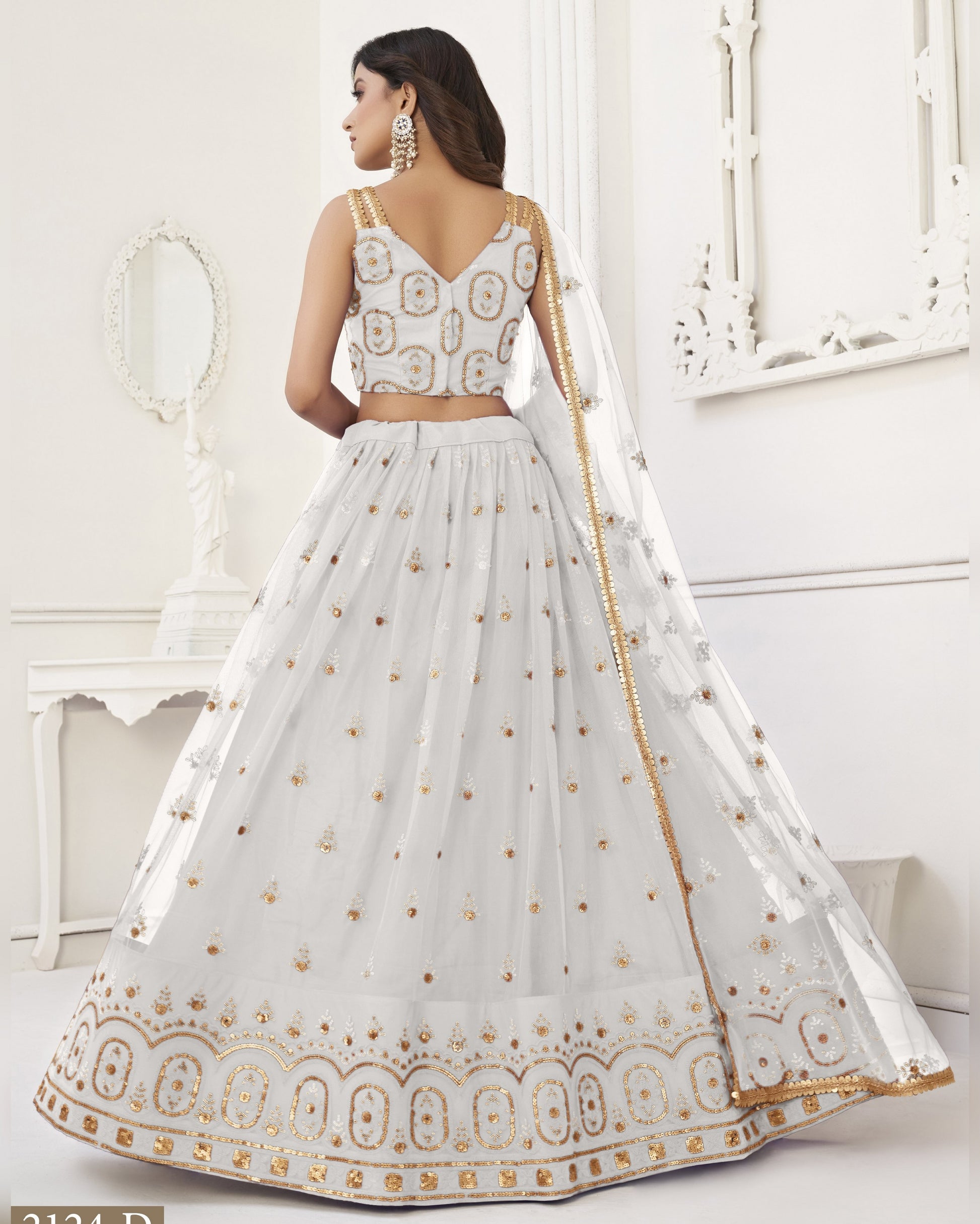White embroidered traditional outfit with gold details on a white background