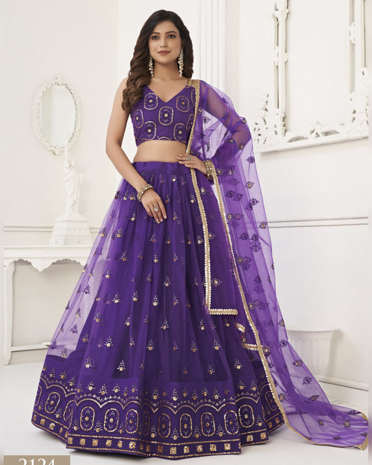 Woman wearing a purple embroidered lehenga with a white background