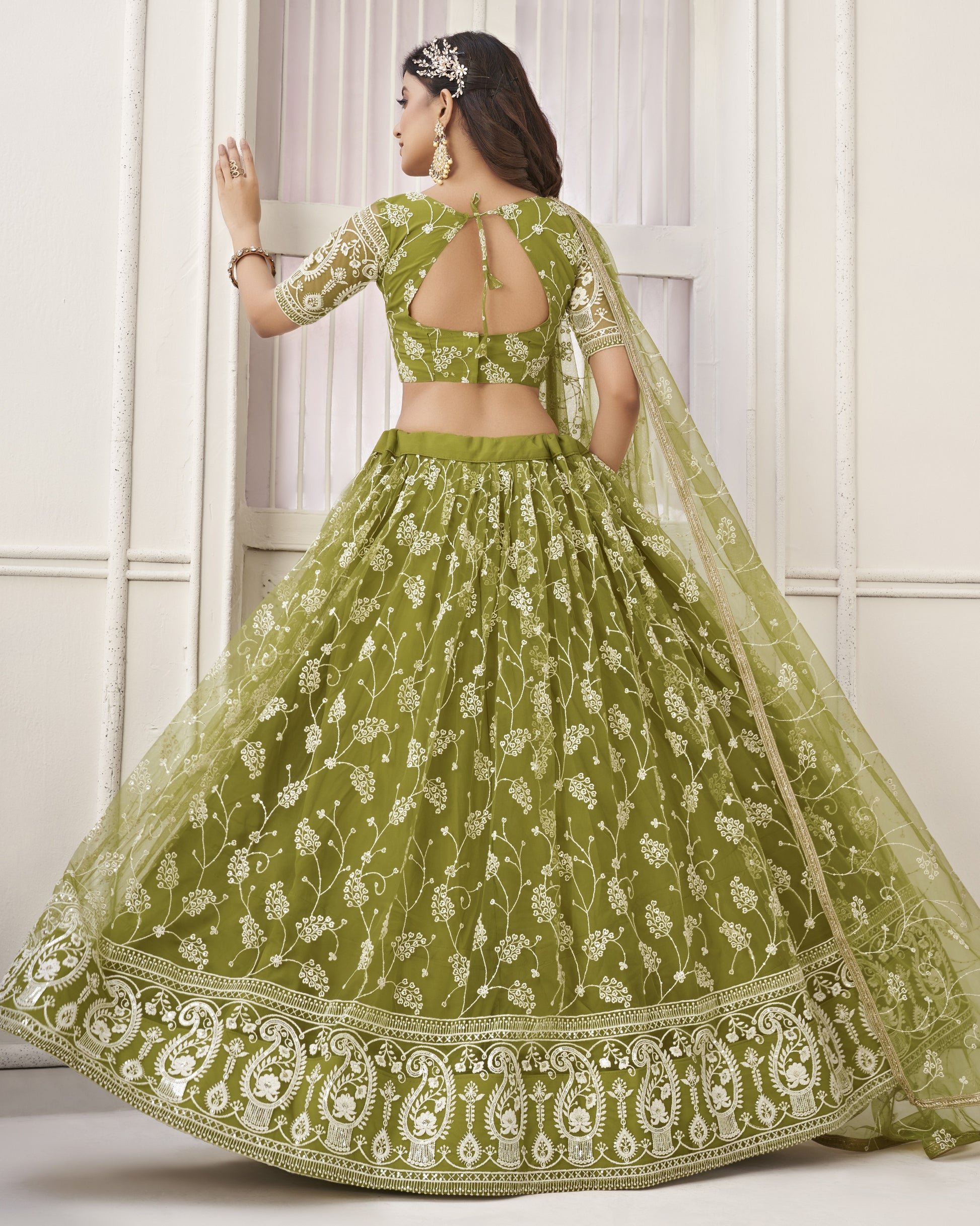 Green embroidered lehenga with a white floral pattern on a white background