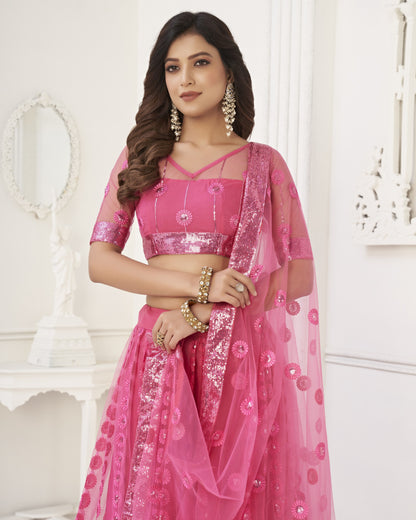 Woman wearing a pink traditional outfit with sequin details against a white background