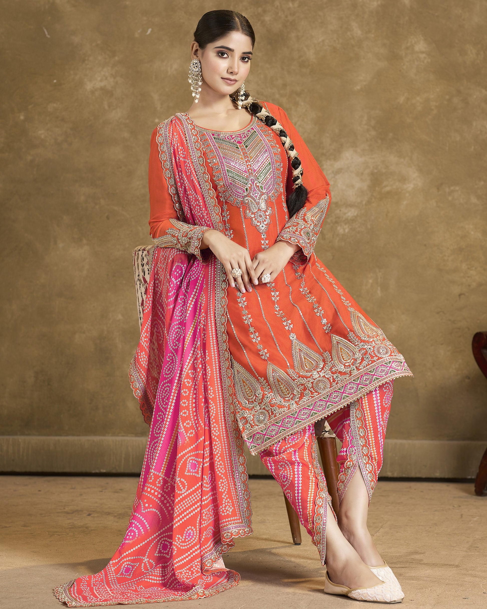 Woman wearing a traditional outfit with red and pink patterns on a brown background