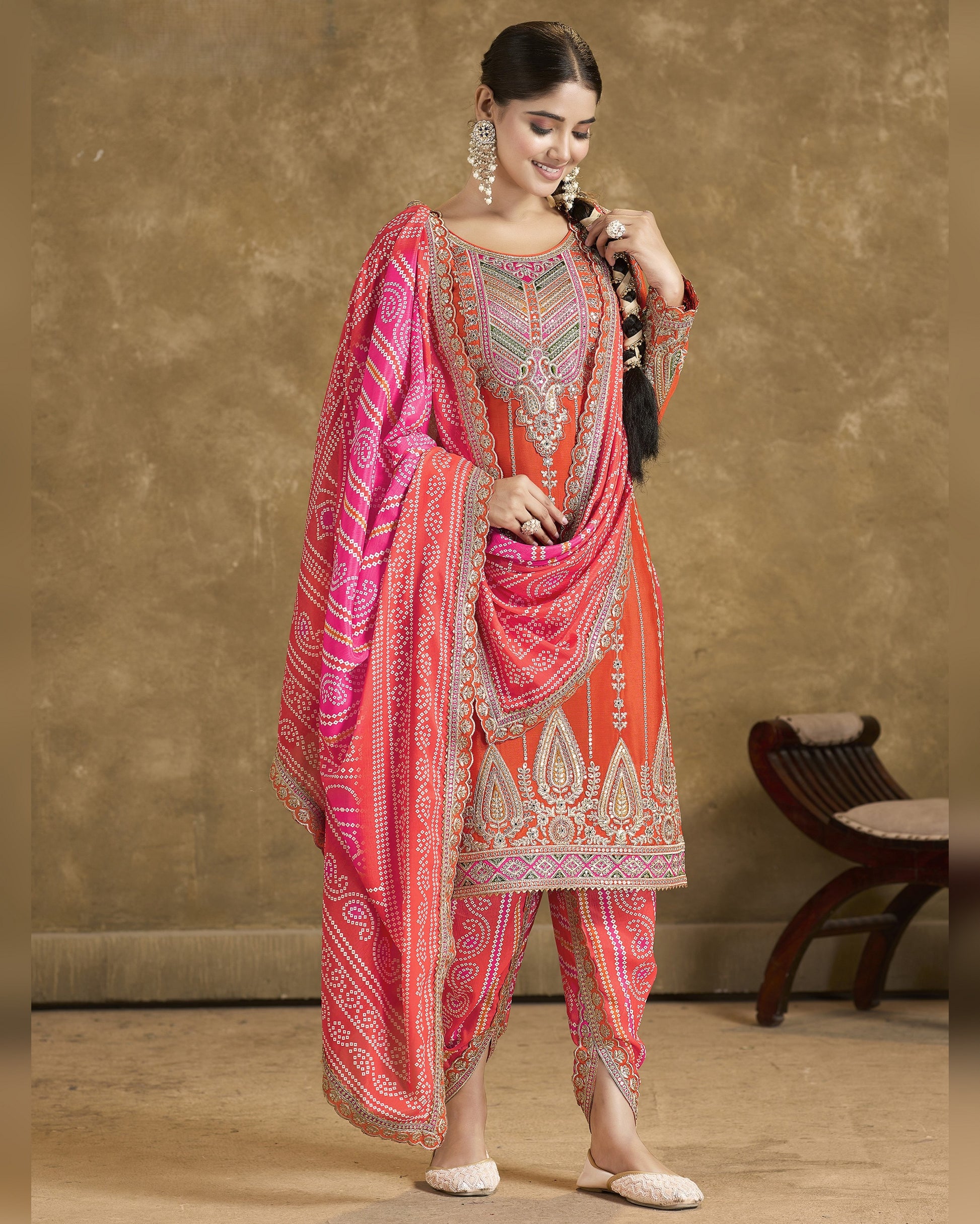 Woman wearing a traditional pink and red patterned outfit against a neutral background