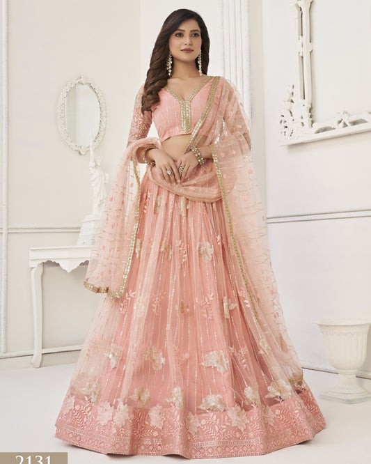 Woman wearing a pink embroidered traditional outfit in a white room.