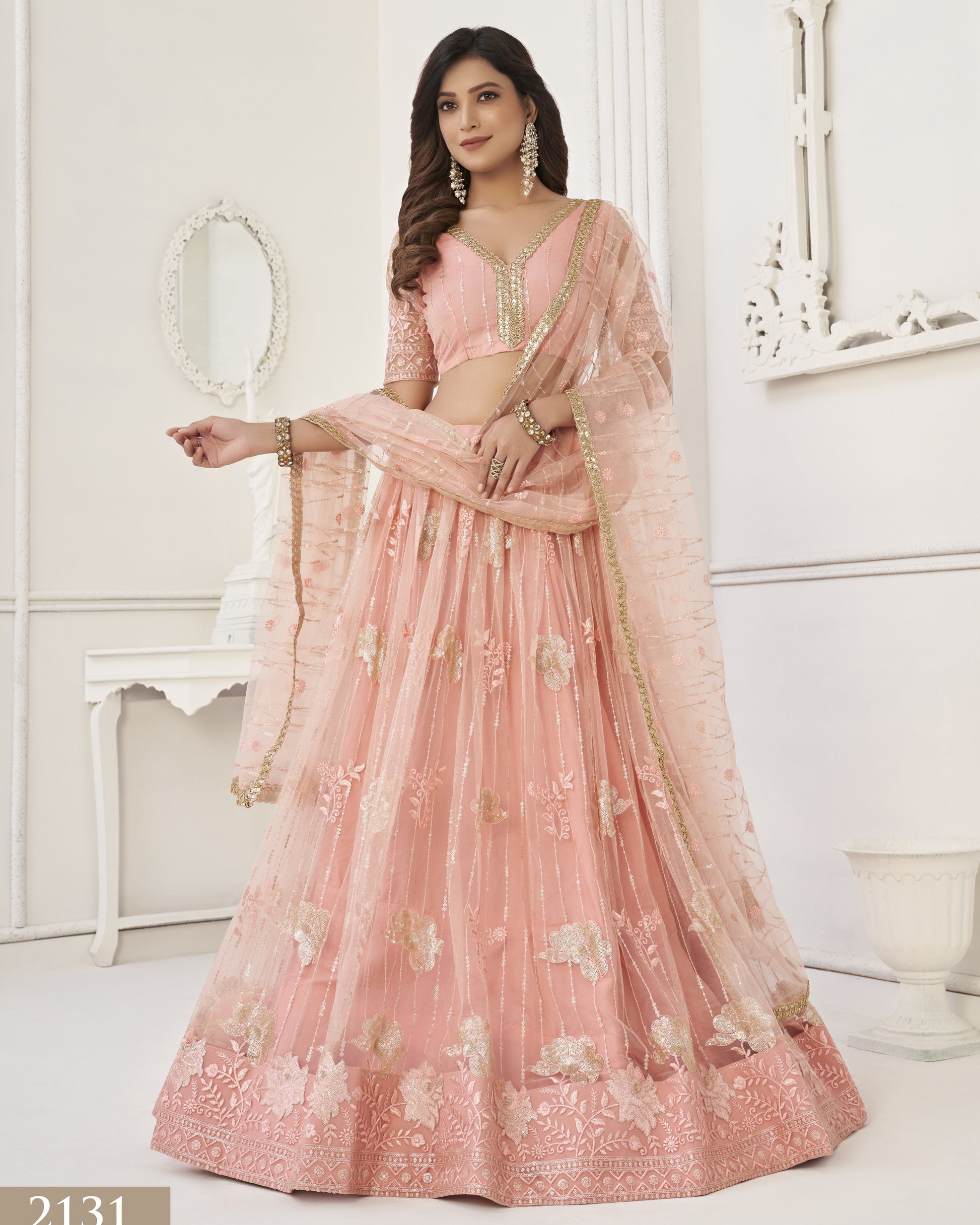 Woman wearing a pink embroidered saree in an elegant indoor setting
