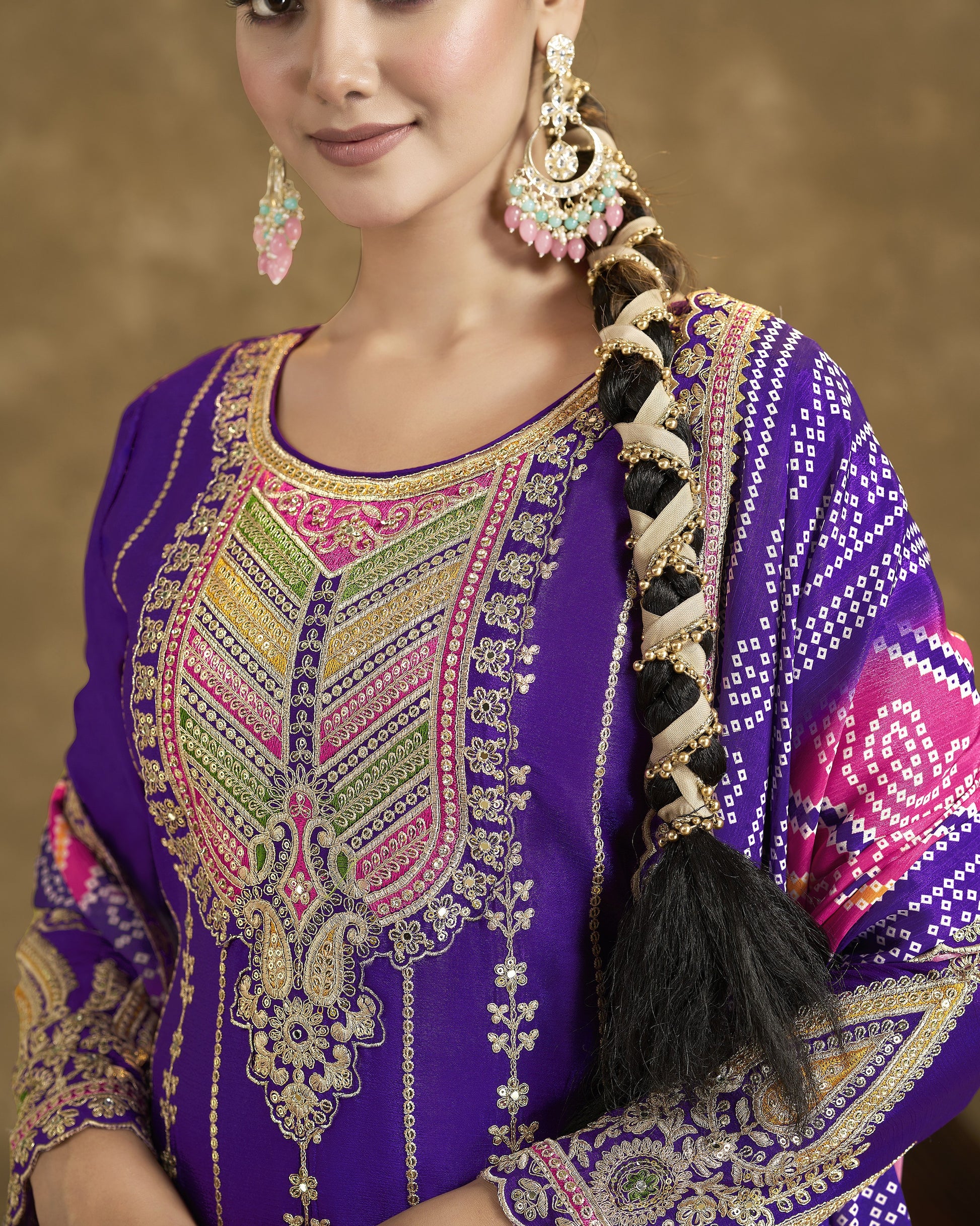Woman wearing a purple embroidered traditional outfit with decorative hair accessories.