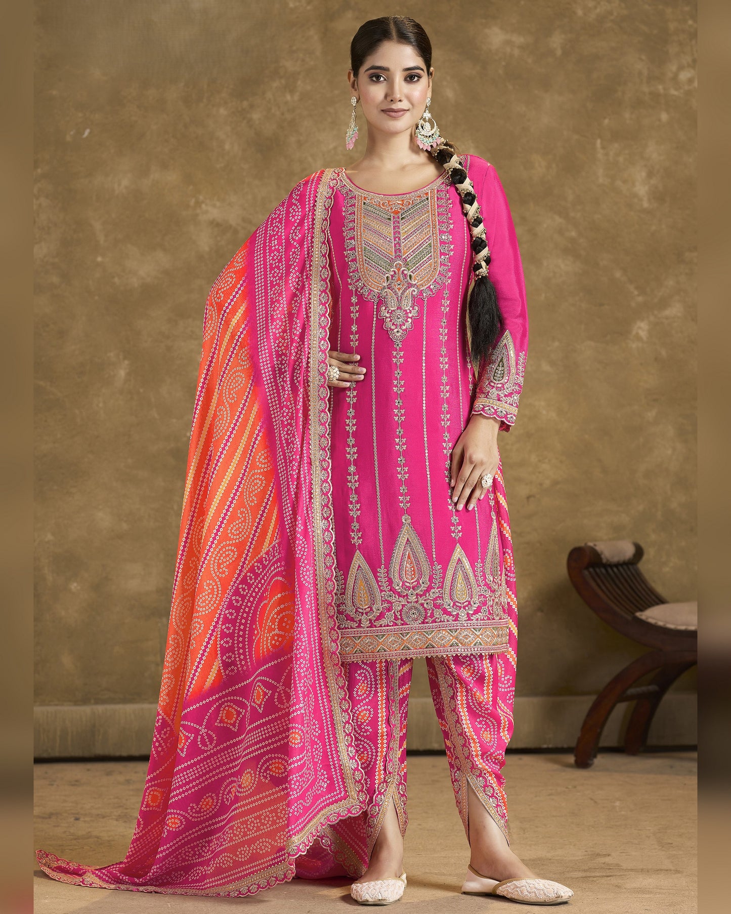 Woman wearing a pink traditional outfit with a matching dupatta against a neutral background