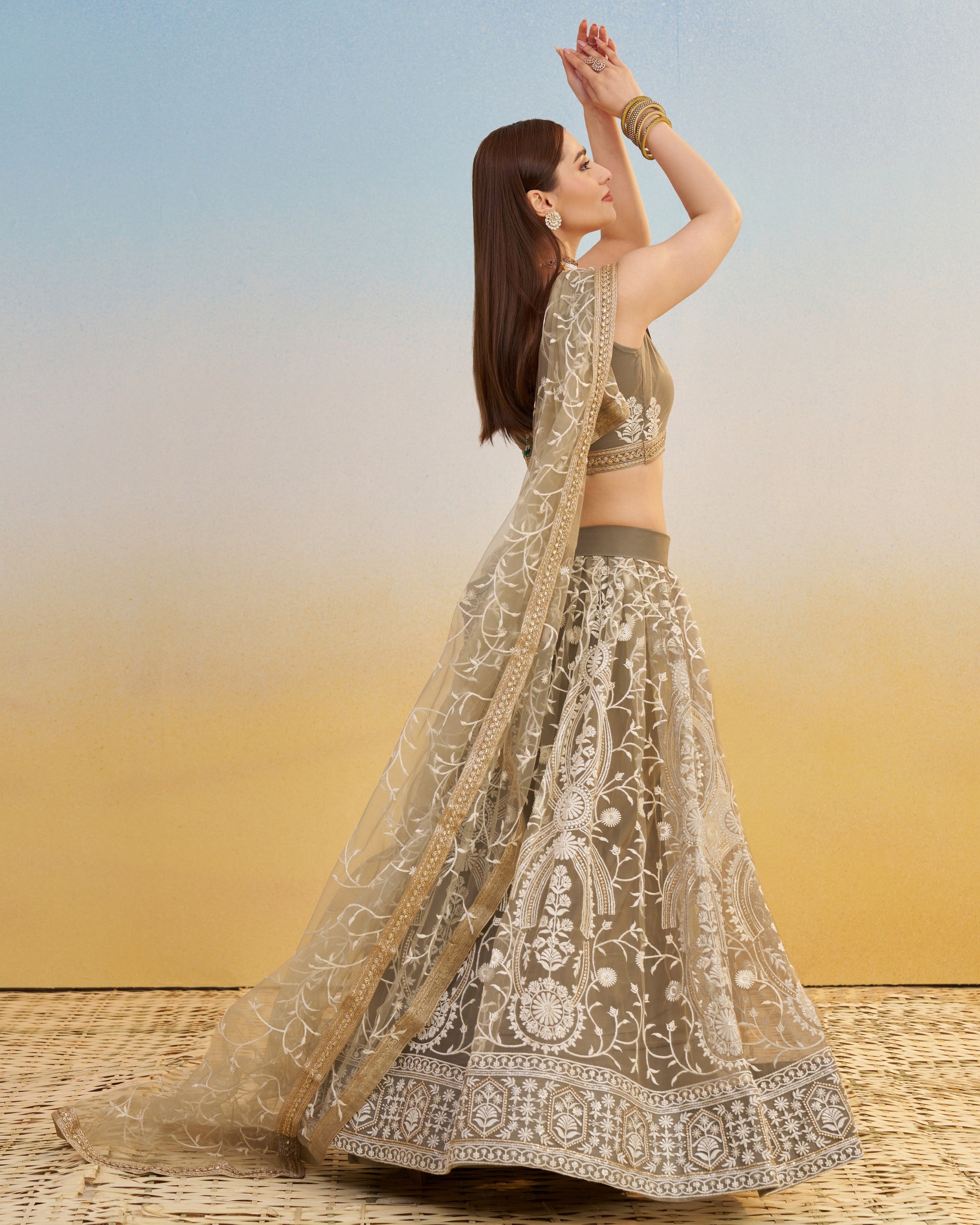 Woman in traditional embroidered lehenga with a gradient background
