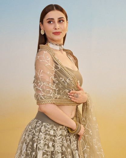 Woman in traditional outfit with floral patterns against a gradient background