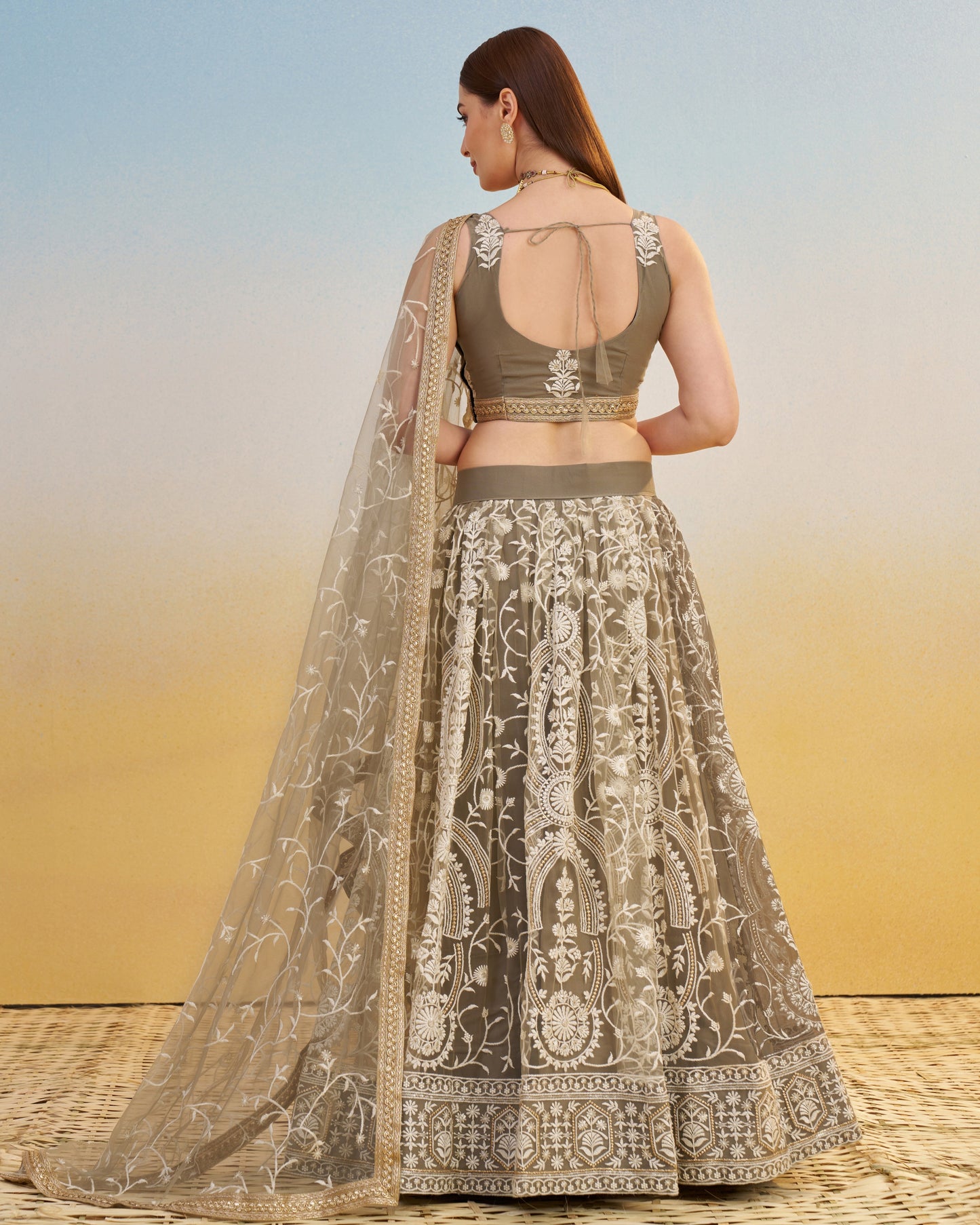 Woman wearing a traditional outfit with a floral pattern against a gradient background