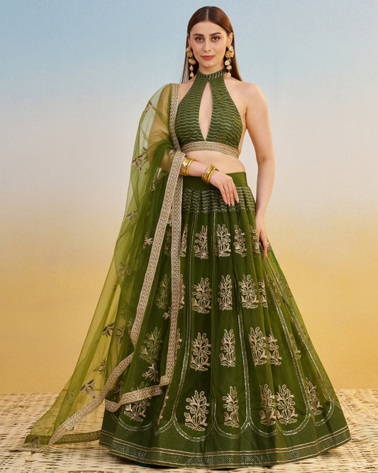 Green embroidered lehenga with matching top on a blurred background