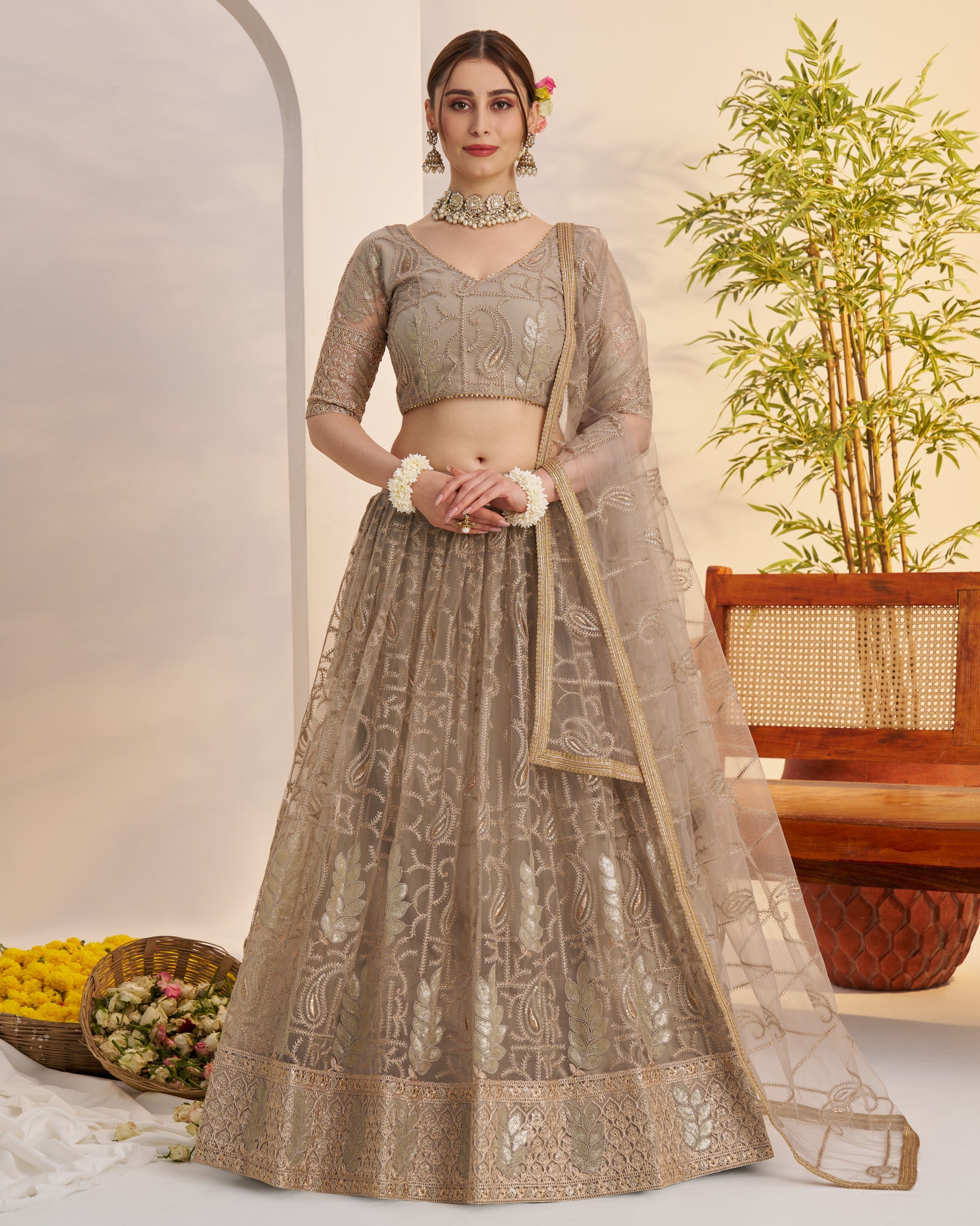 Woman wearing an embroidered lehenga with a neutral background