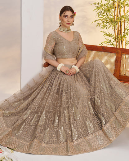 Woman in a traditional embroidered outfit sitting on a chair with a plant in the background