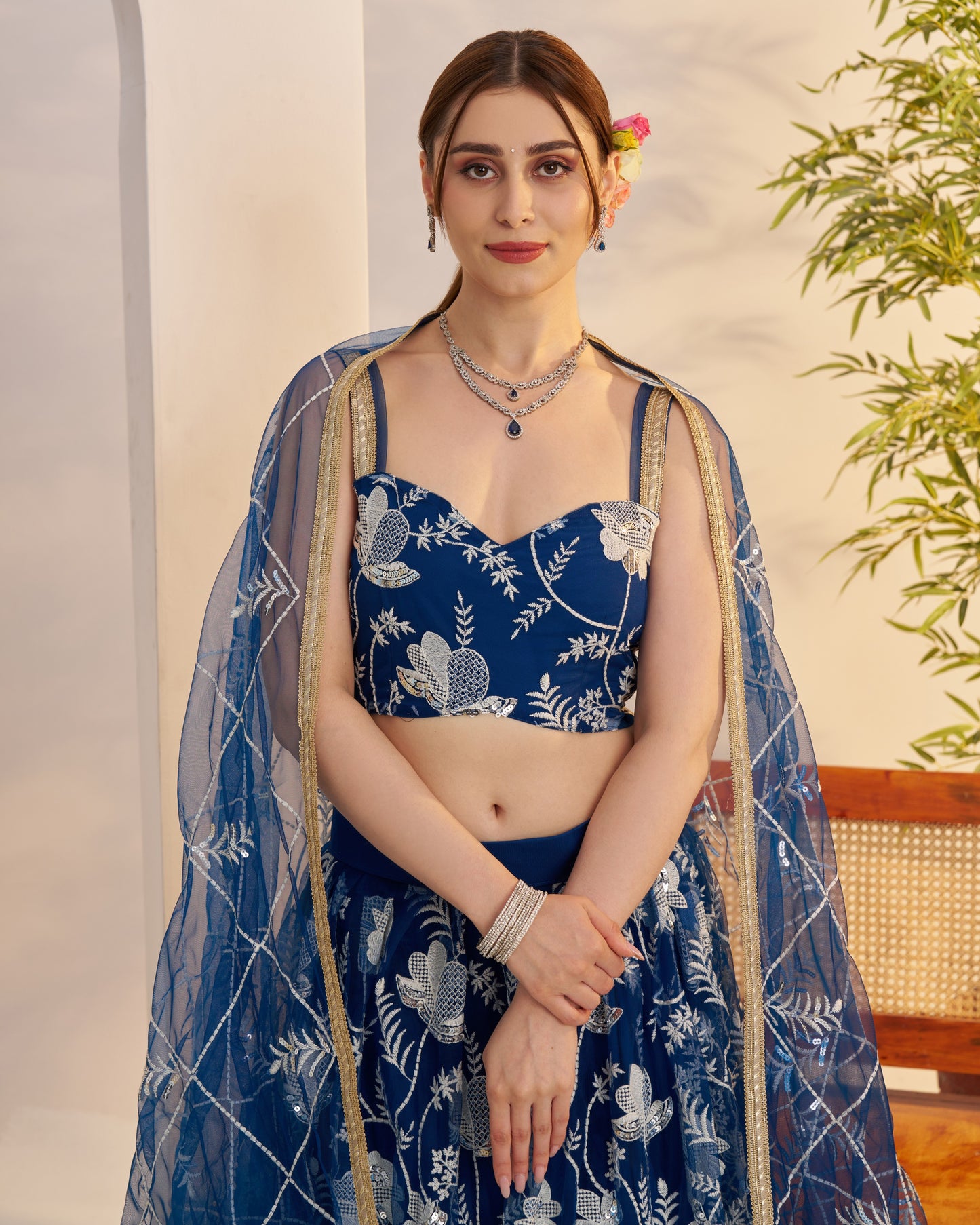 Woman wearing a blue floral traditional outfit with a light background