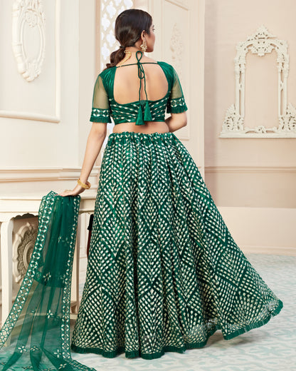 Woman wearing a green and white patterned saree in an elegant interior setting