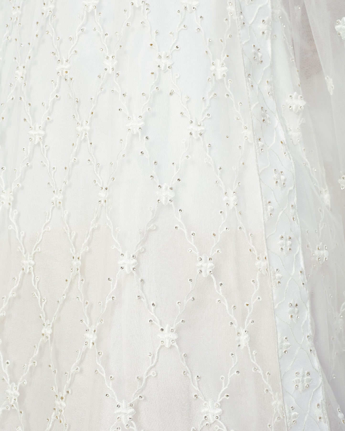 Close-up of white fabric with delicate floral embroidery