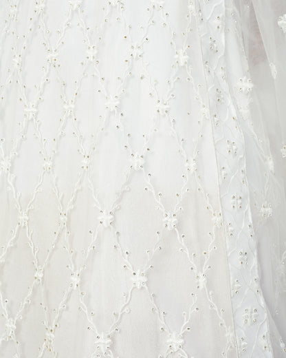 Close-up of white fabric with delicate floral embroidery