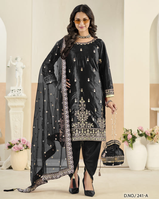 Woman in black embroidered outfit with sheer dupatta in a decorated room