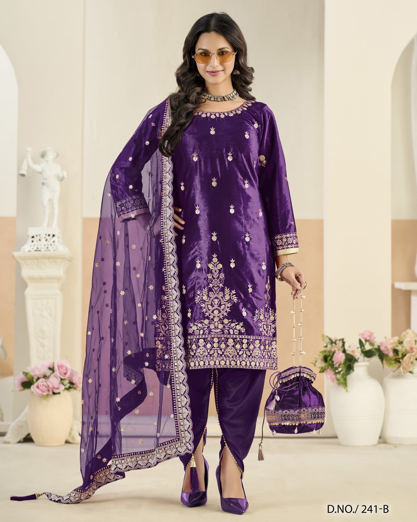 Woman wearing a purple embroidered outfit with a matching dupatta in an elegant indoor setting.