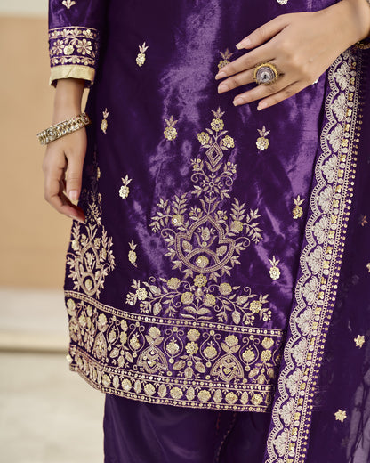 Purple embroidered garment with gold details on a neutral background