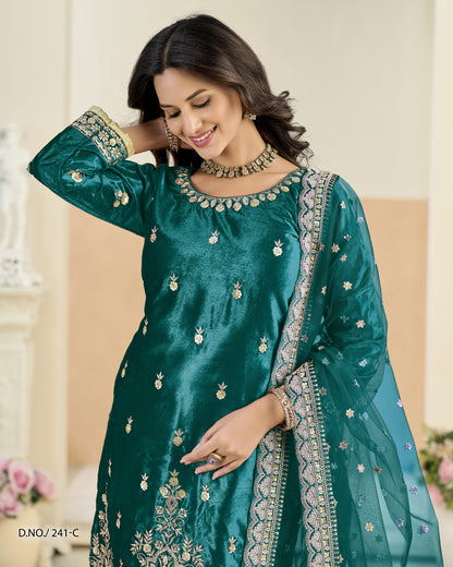 Woman wearing a teal embroidered traditional outfit with a blurred background