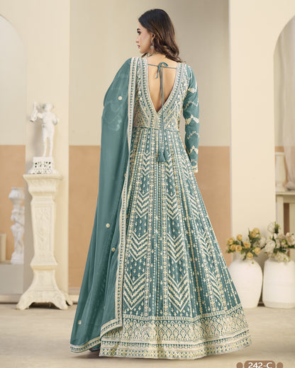 Woman wearing a teal and white patterned dress with a matching dupatta in an indoor setting.