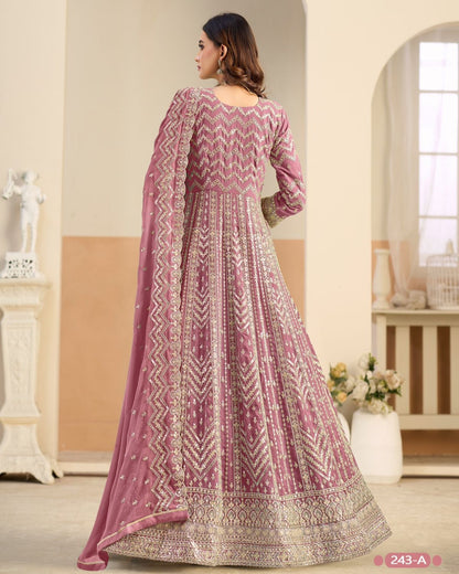 Woman wearing a pink and white patterned traditional outfit in a well-lit room.