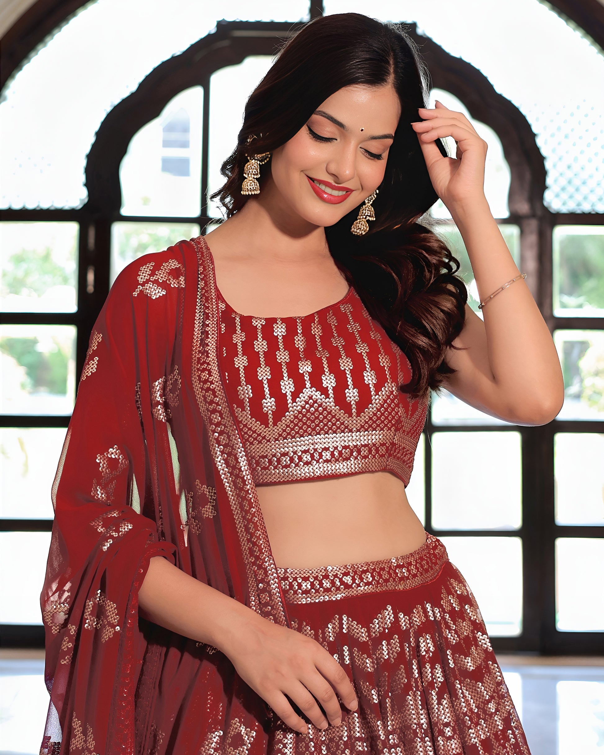 Woman wearing a red embroidered saree with a blurred background