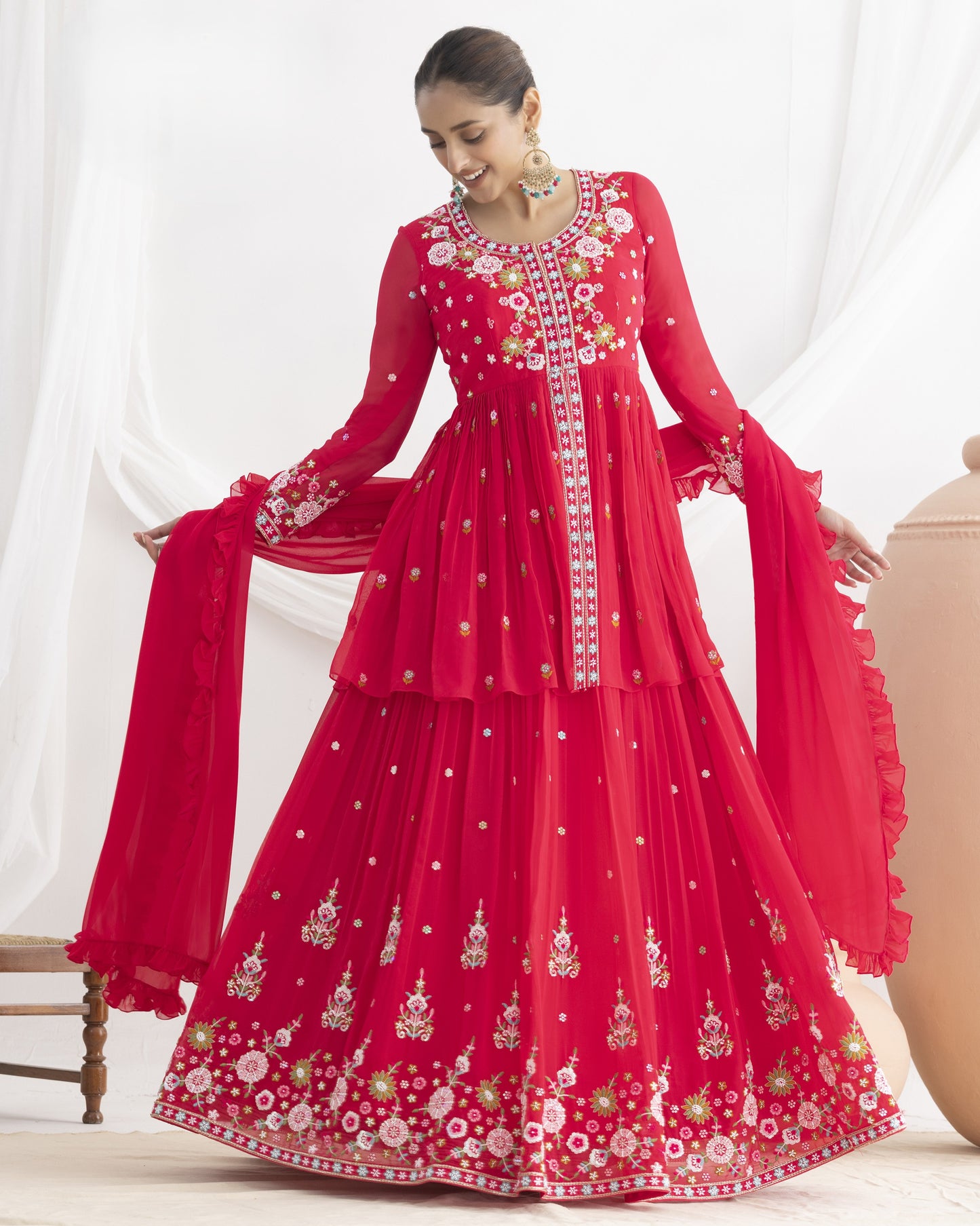 Woman wearing a red embroidered traditional outfit on a white background